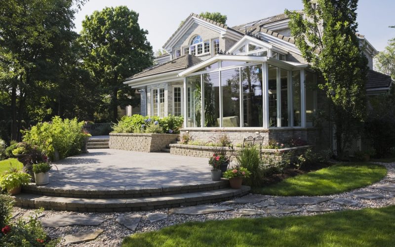 Brick and stone cottage style home with sunroom, patio and landscaped backyard, Quebec, Canada