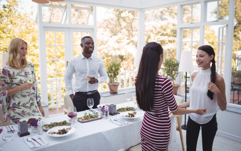 Group of friends interacting with each other during lunch in restaurant